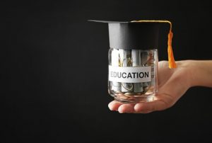 holding glass jar with money for education